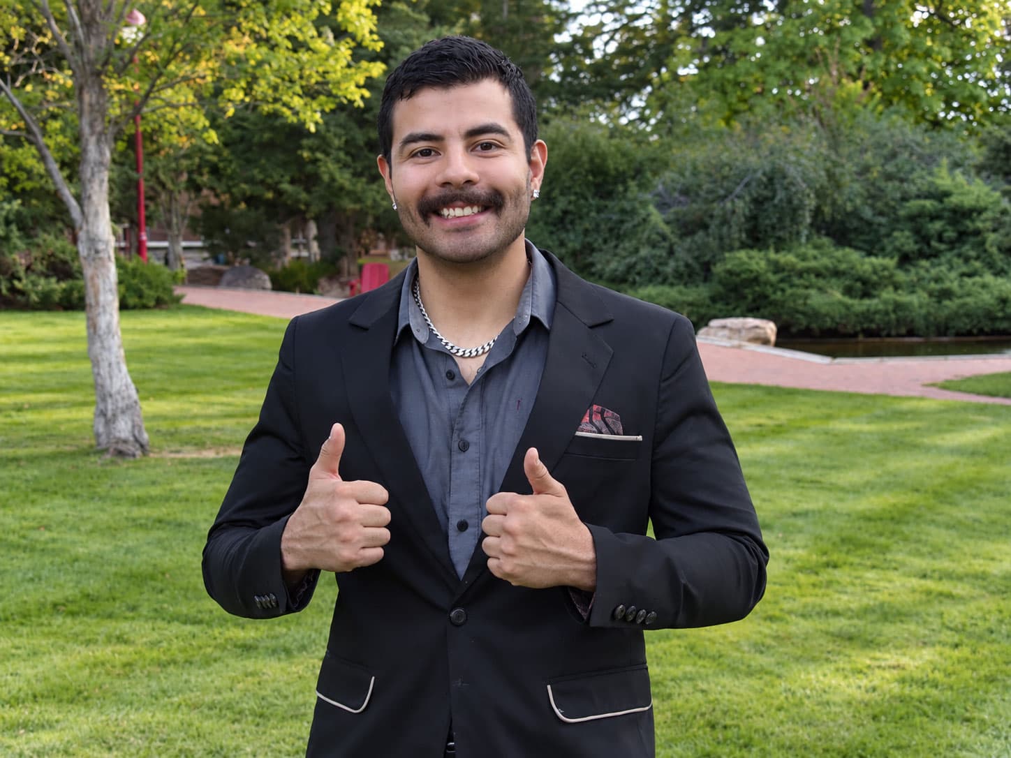 Ted Martinez, founder of Precise Wolf Digital, giving two thumbs up in a park